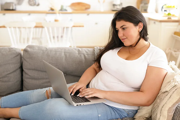 Woman on her laptop while sitting on the couch