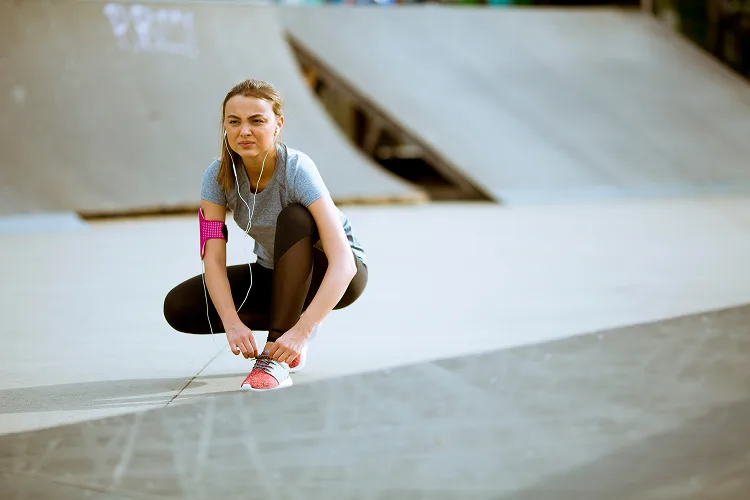 Girl in a skatepark binding shoe-lace
