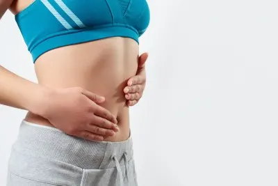 Girl massaging tummy with essential oils