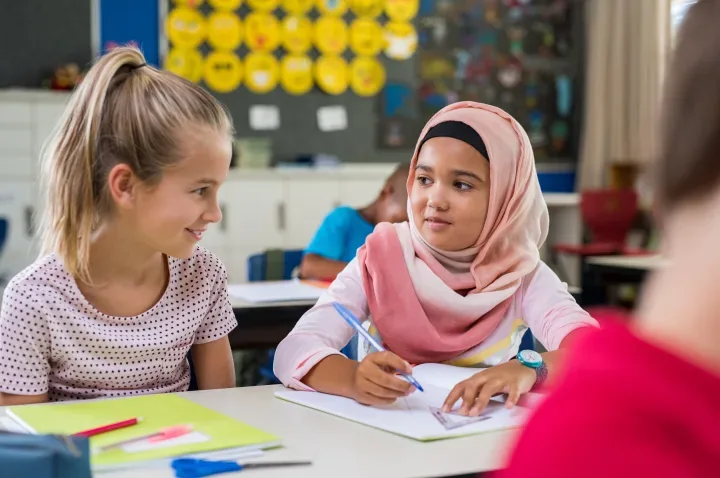 Two girls sitting at a table in school