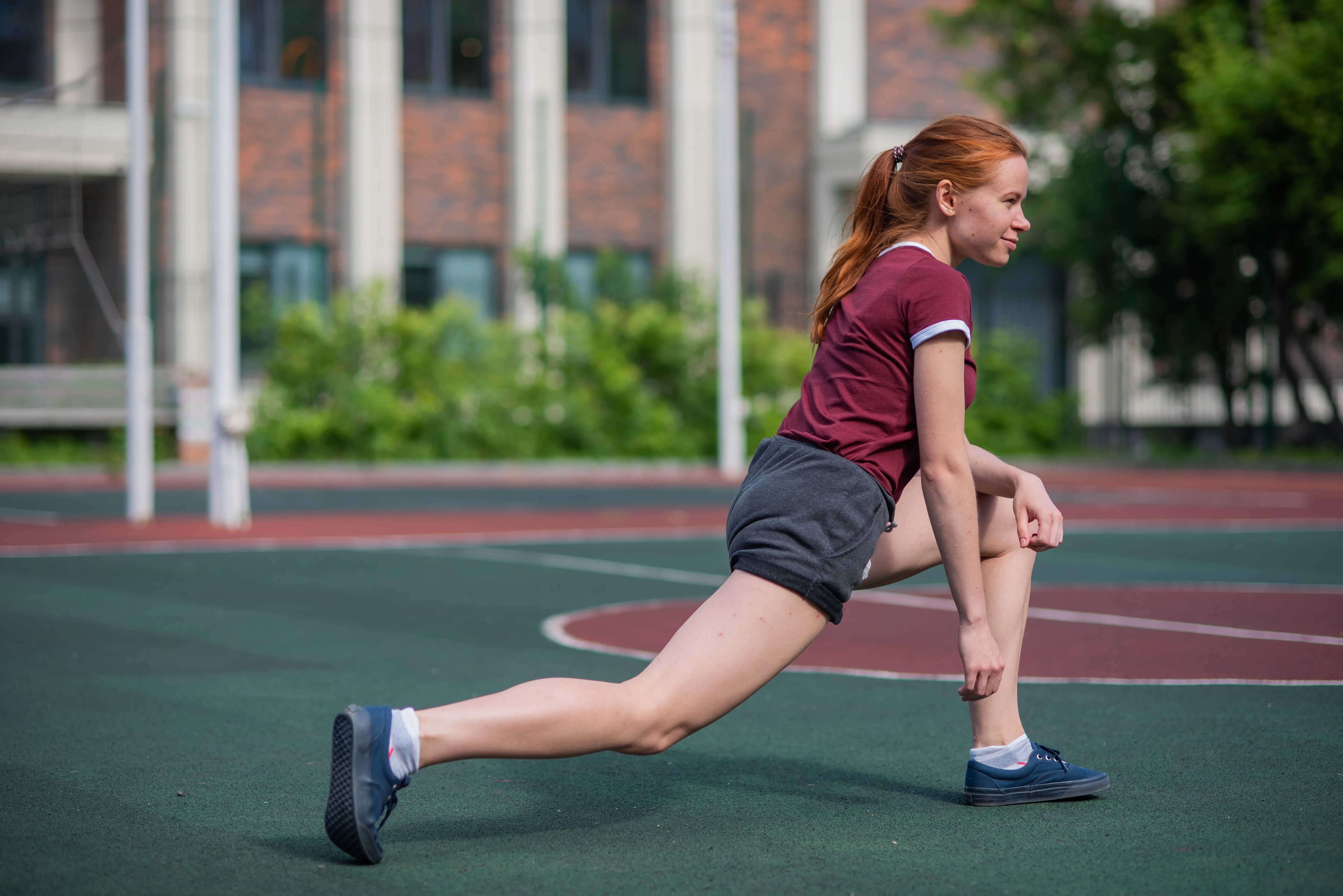 Girl in a lunge position on a basketball field