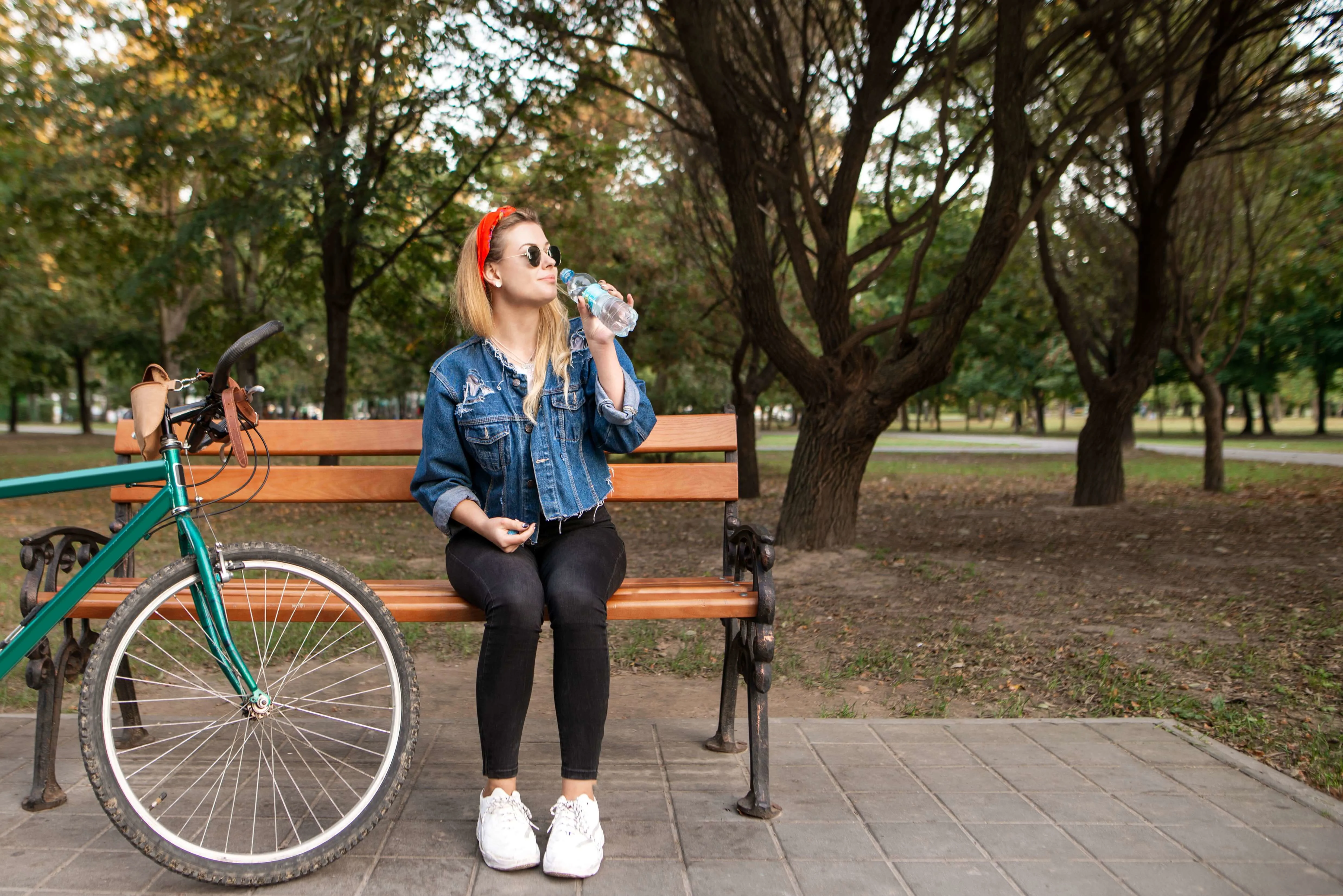 Girl sitting in a park drinking water