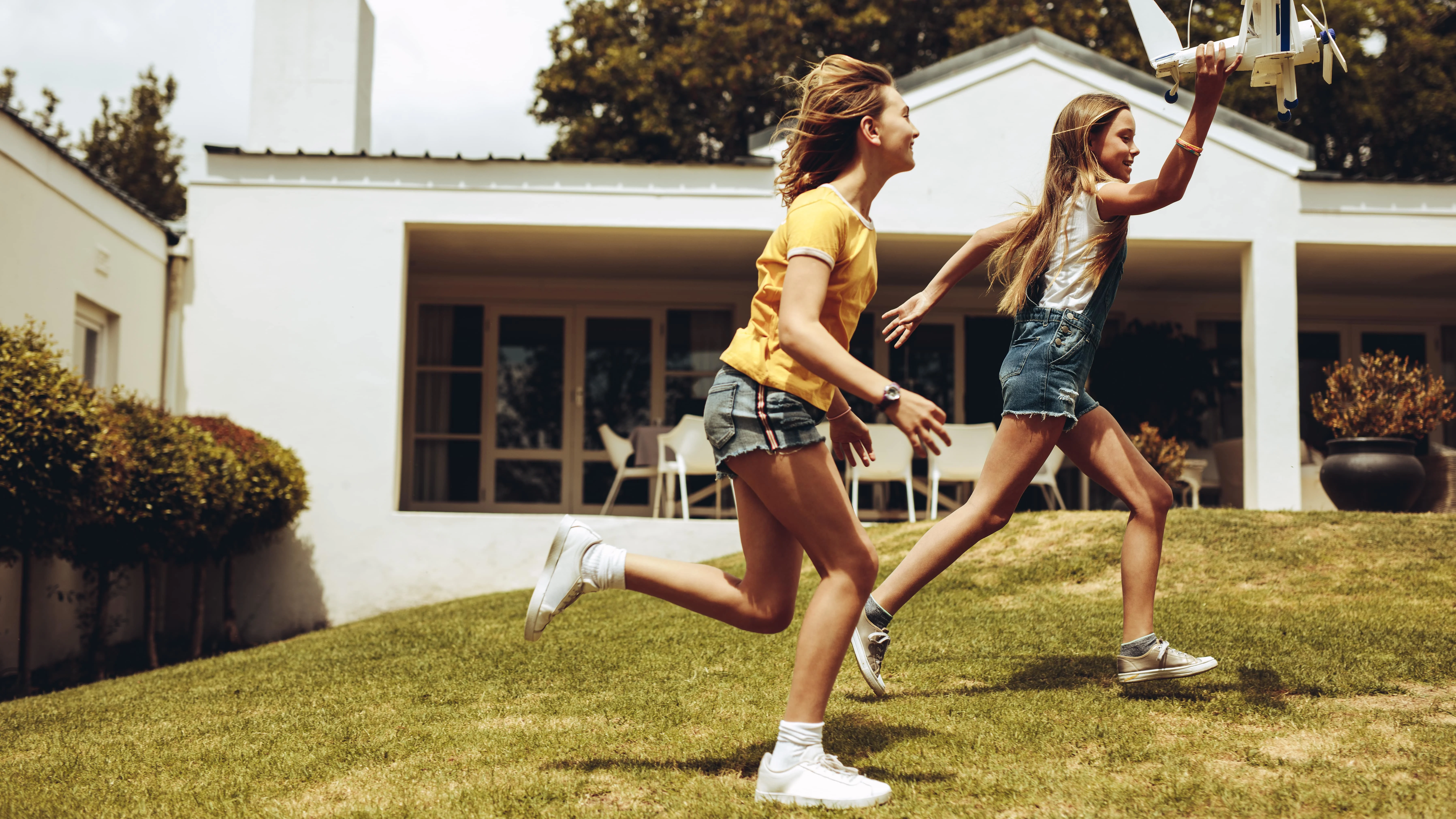 Two teenage girls playing in a yard