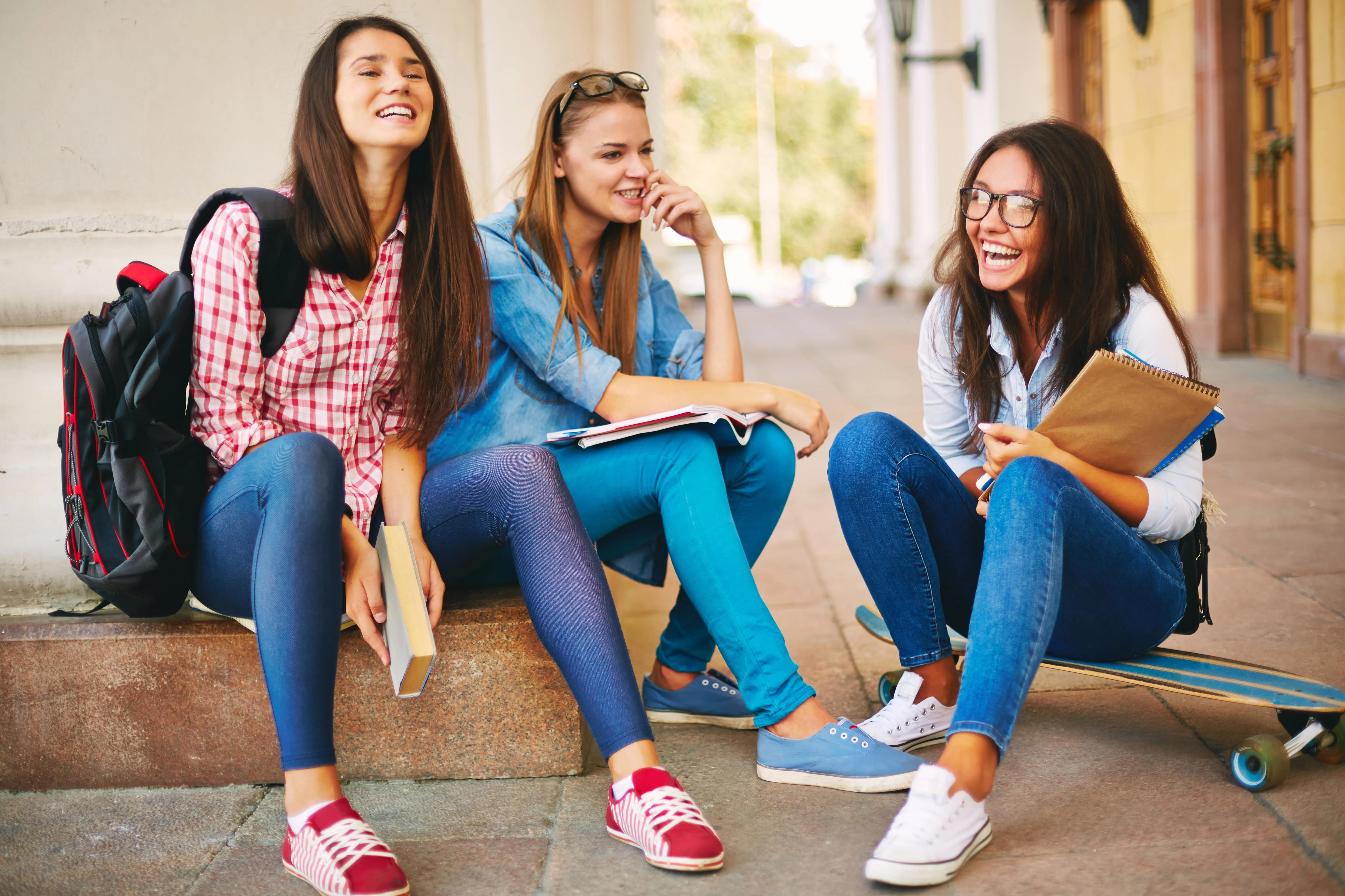 Girls sitting outdoors and smiling