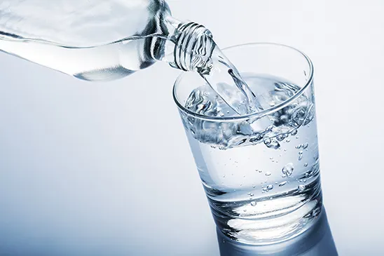 Pouring water from bottle into glass