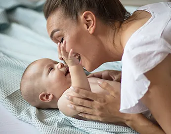 Mom playing with a newborn baby