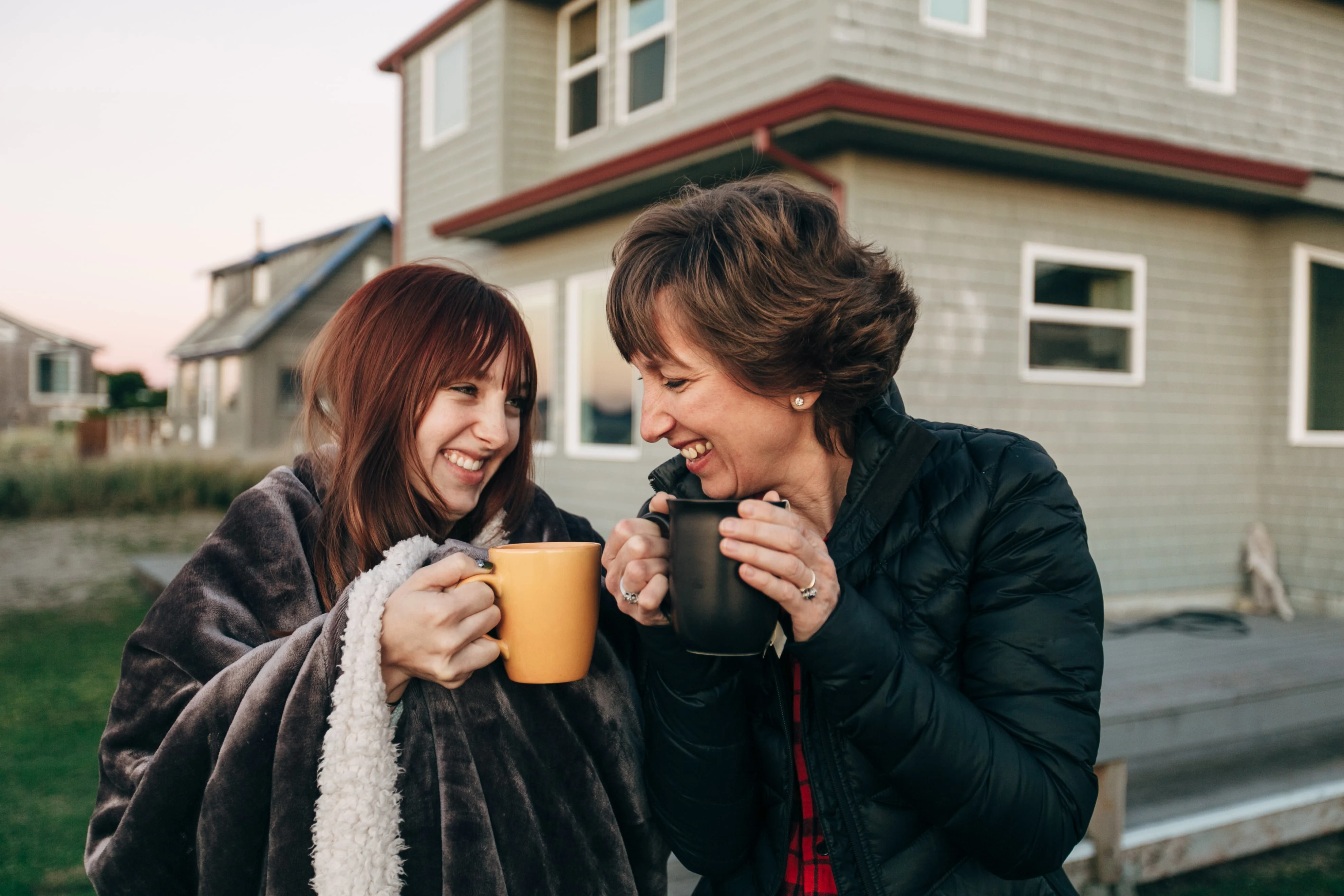 Daughter and mother drinking tea outside and smiling