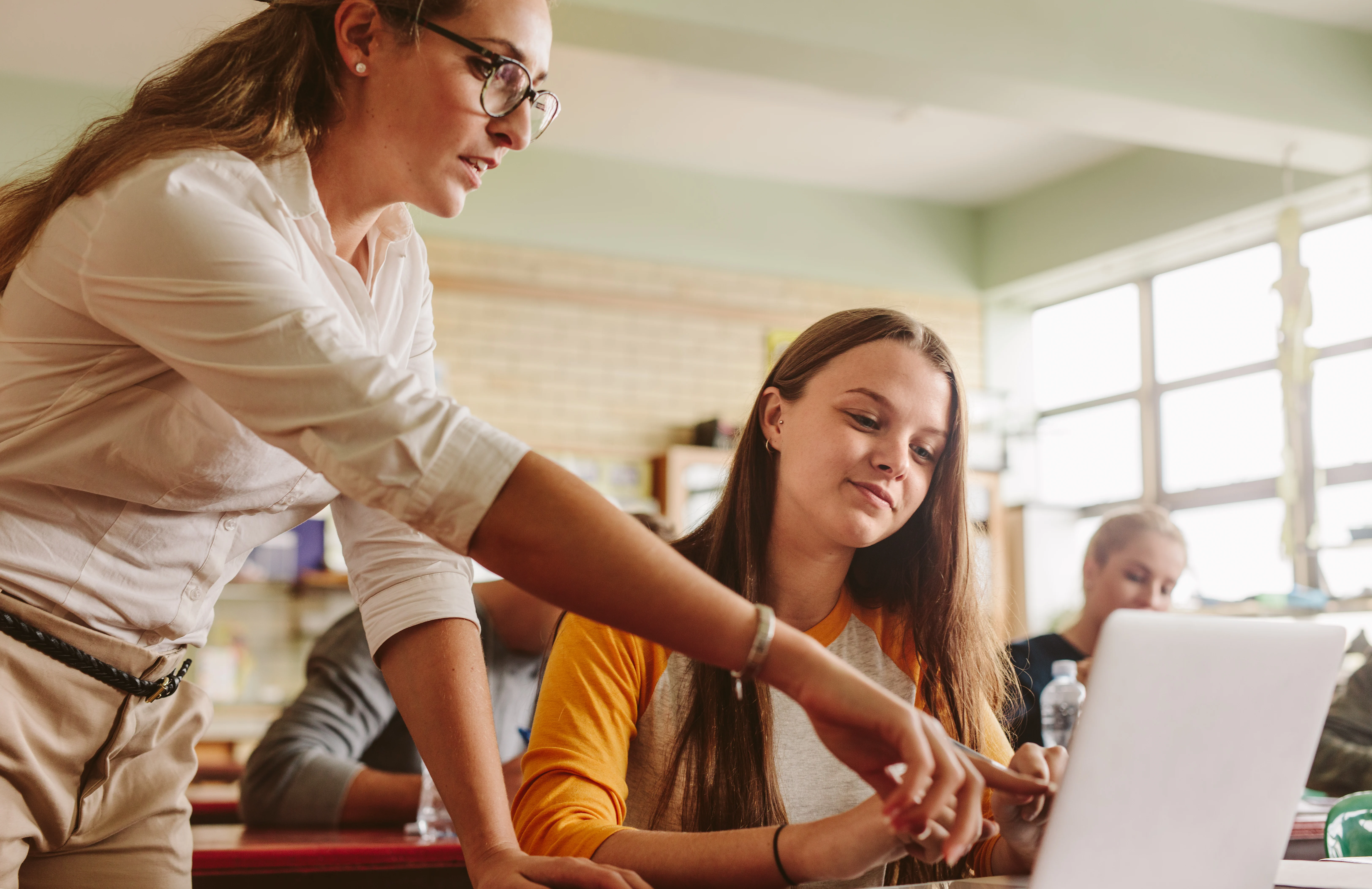 Teacher explaining something to a schoolgirl aged 13-14