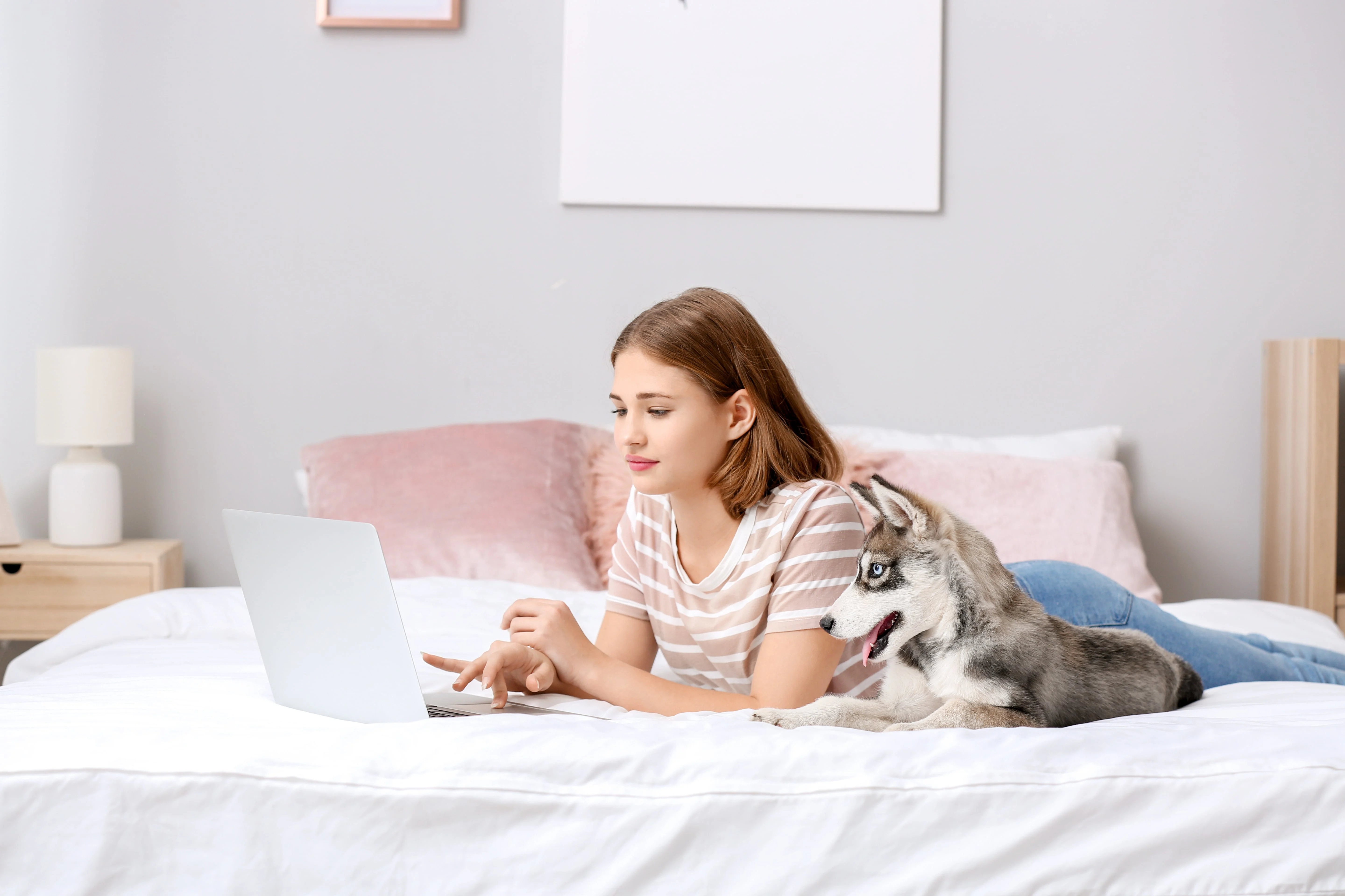 Girl lying on the bed using a laptop