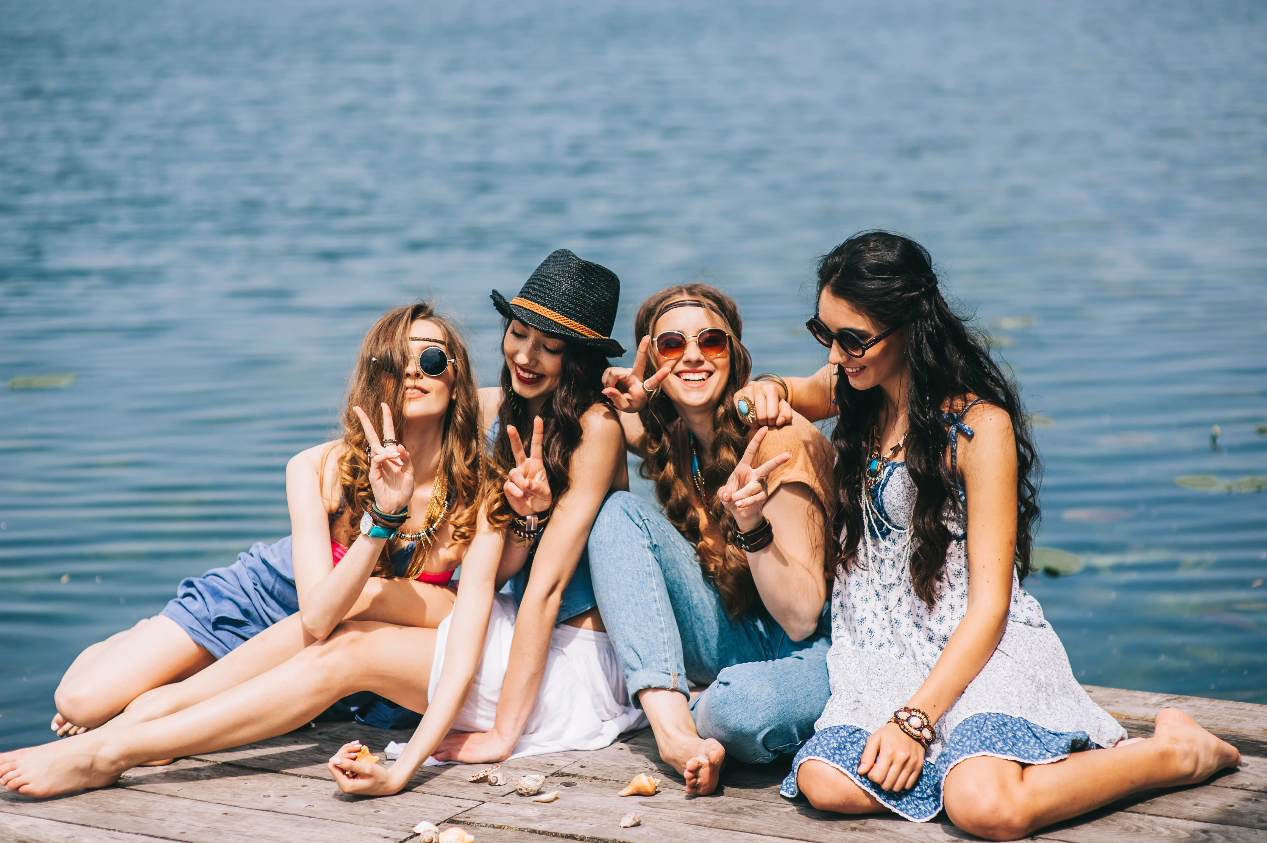 Four girl sitting on a dock and smiling