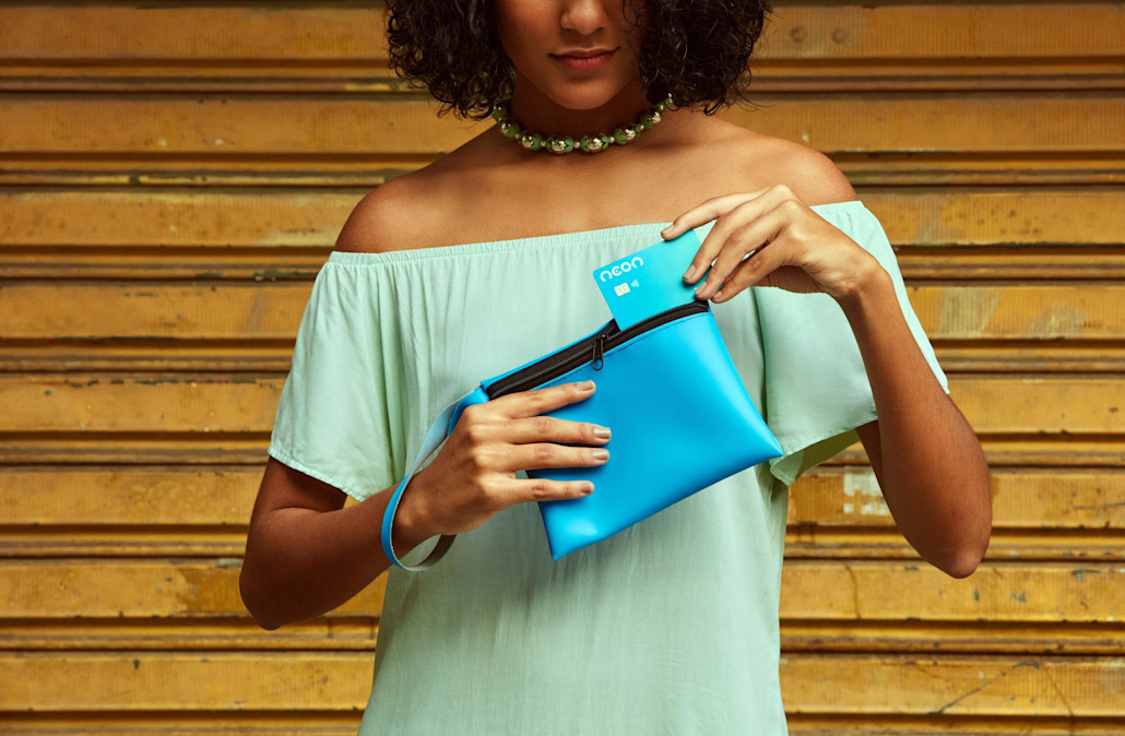 Woman holding Neon Bank card.