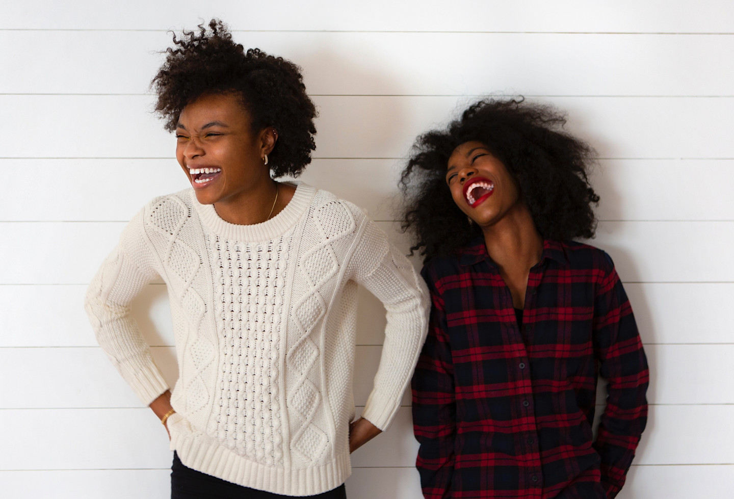 women-laughing-against-white-wall