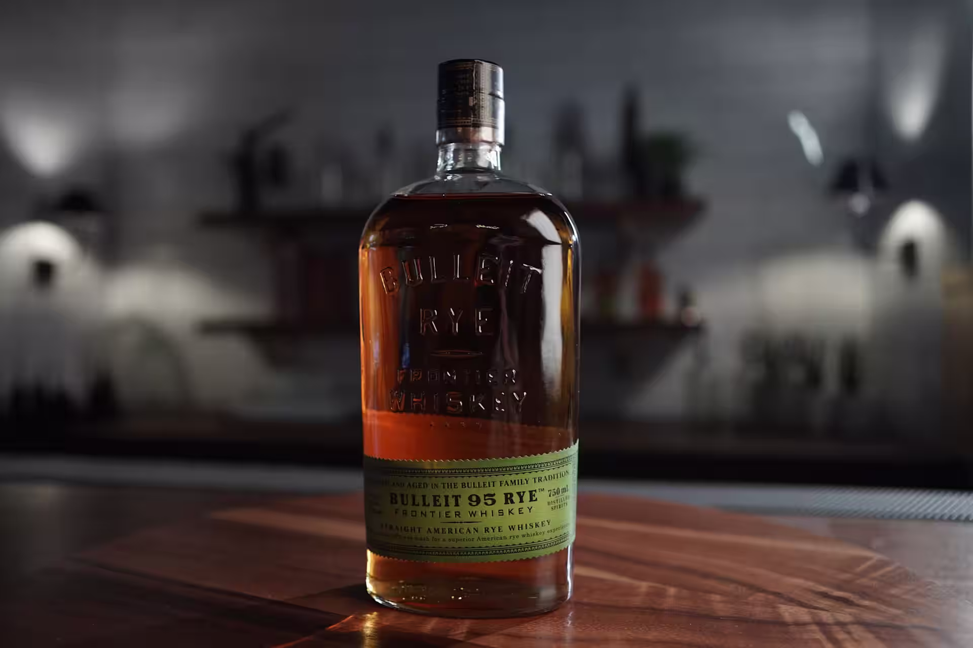 A bottle of Bulleit Rye and a glass containing a shot of Bulleit Rye Whiskey