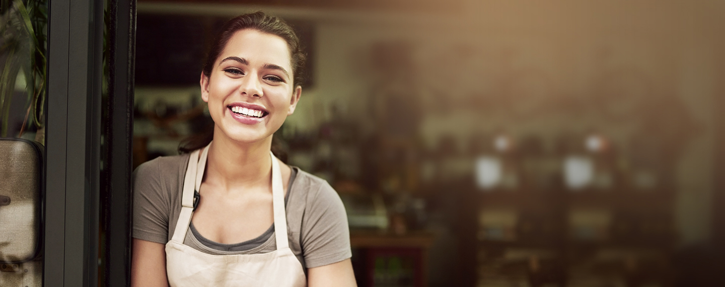 Female small business owner standing outside shop