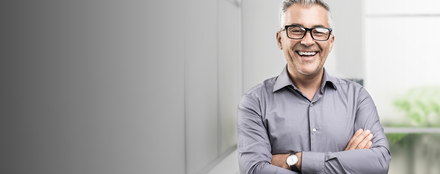 Older gentlemen with crossed arms smiling