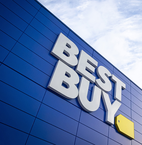 News - Facing up at a Best Buy storefront in front of a blue sky with clouds