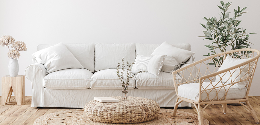 белый диван у белой стены; чехлы на мебель; плетеная мебель; ваза с сухоцветами в интертере