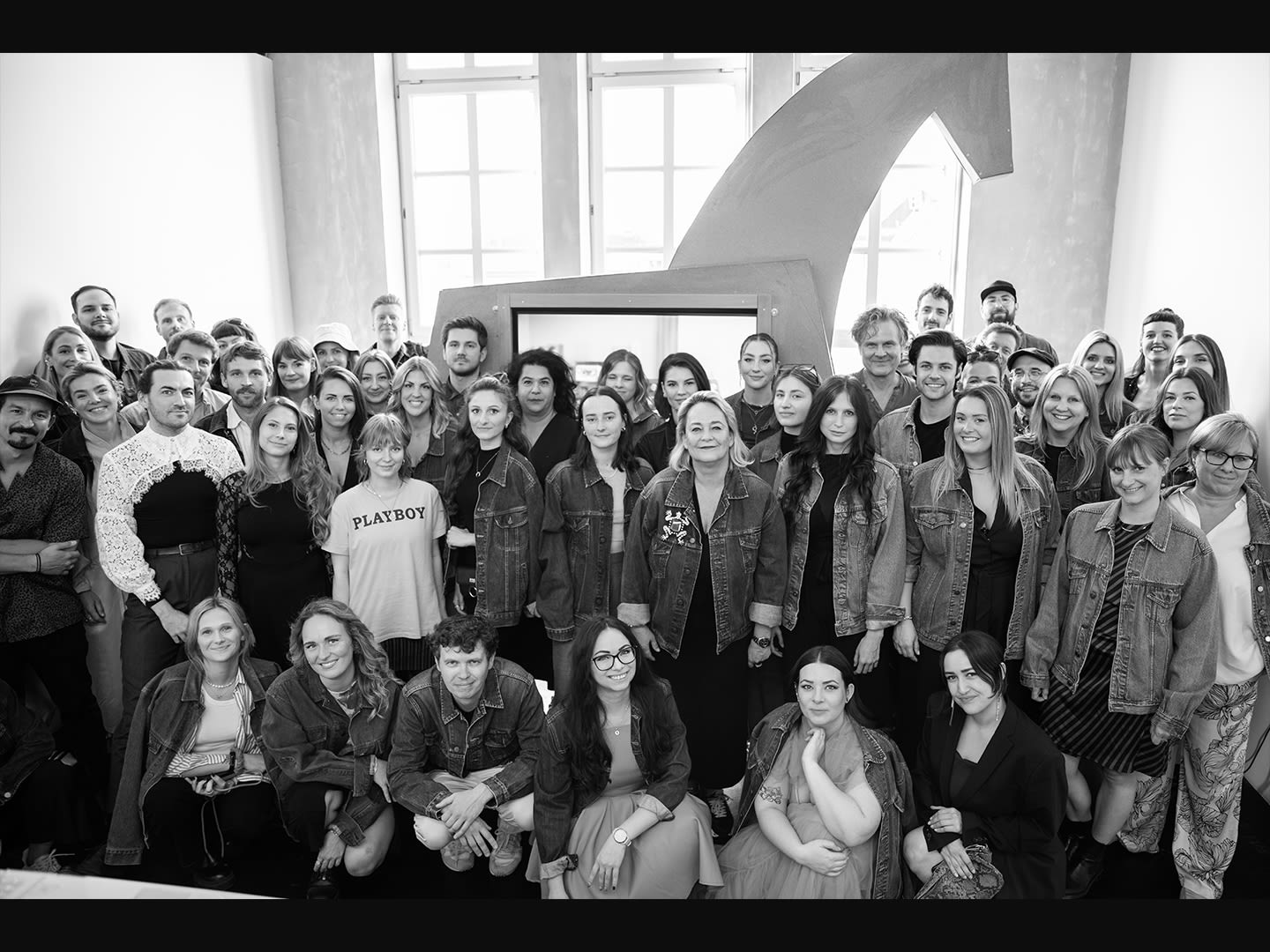 Picture of the employees of Jung von Matt DONAU in Vienna in the office. In the background, a figure of the Trojan horse, Jung von Matt's brand symbol.