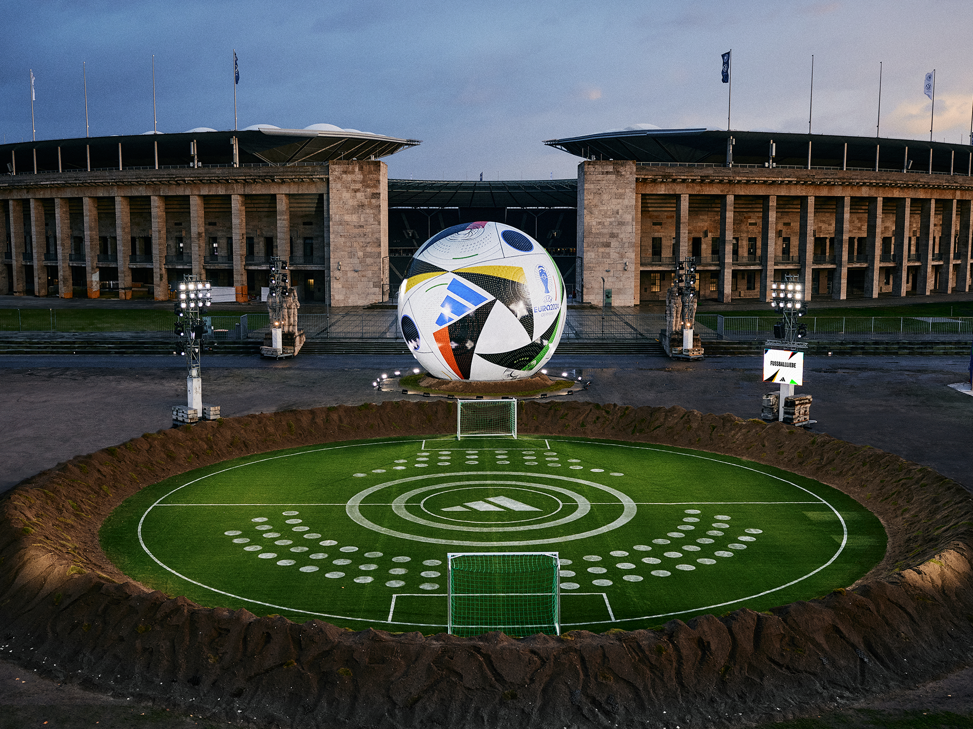 A soccer ball placed in front of a stadium, ready for an exciting match to begin.