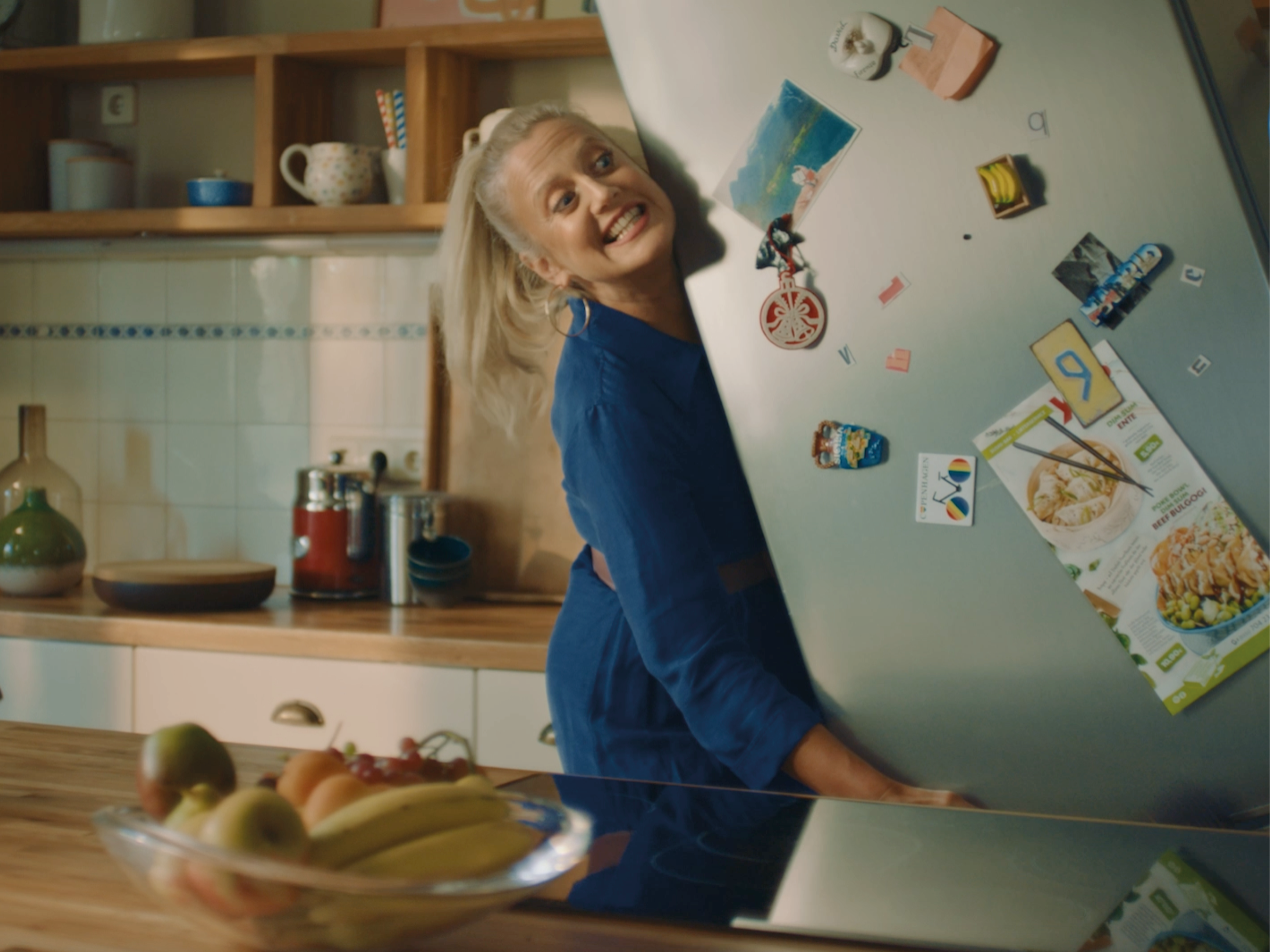 Image of an excerpt from the Jung von Matt Start's brand campaign for Wayfair, showing Barbara Schöneberger laughing and holding a refrigerator.