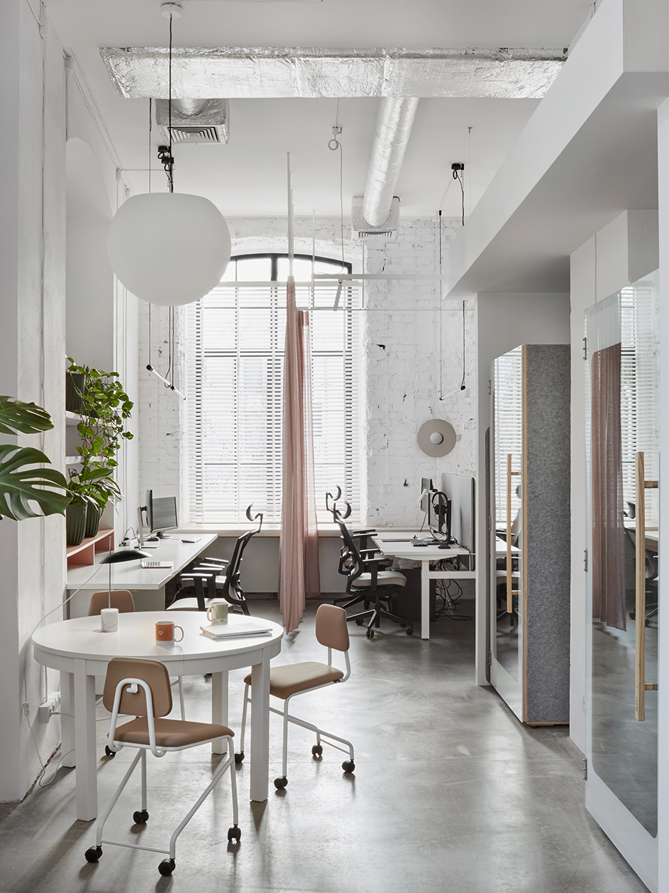 Modern office space featuring white walls and sleek wooden floors.