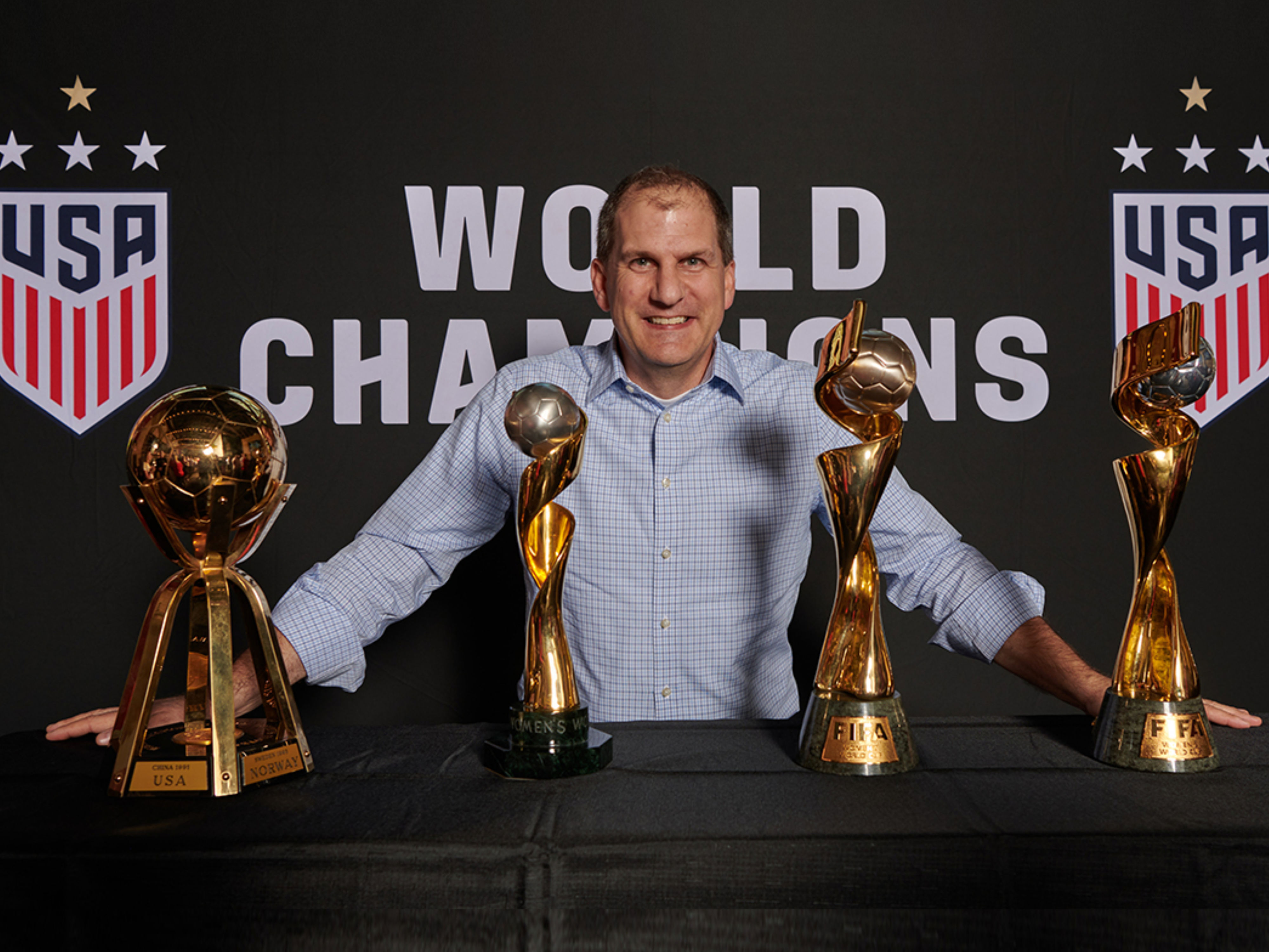 Image of Jung von Matt SPORTS CEO Brian Remedi smiling and standing behind four trophies.