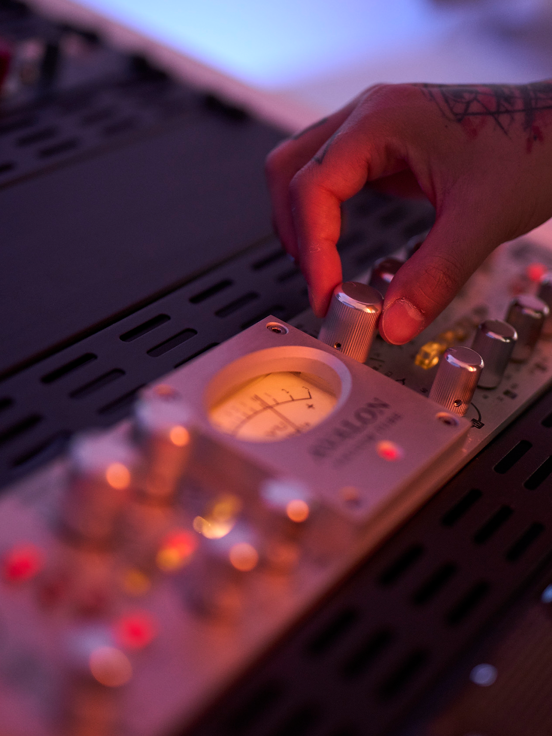 Picture of a tattooed hand turning a knob on a mixer pulse.