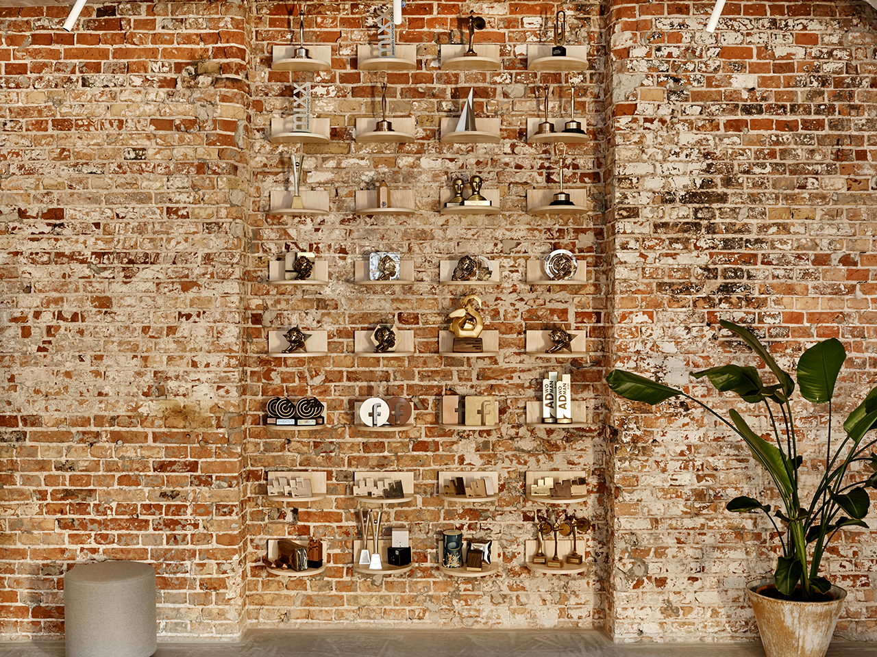 A brick wall with shelves holding a plant