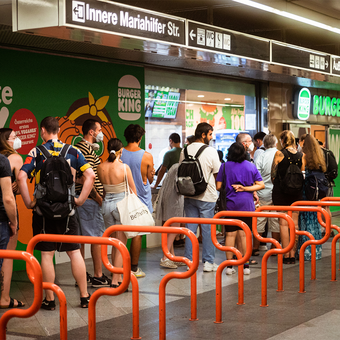 Picture of a group of people standing in line at the first vegan Burger king restaurant in the Westbahnhof in Vienna.