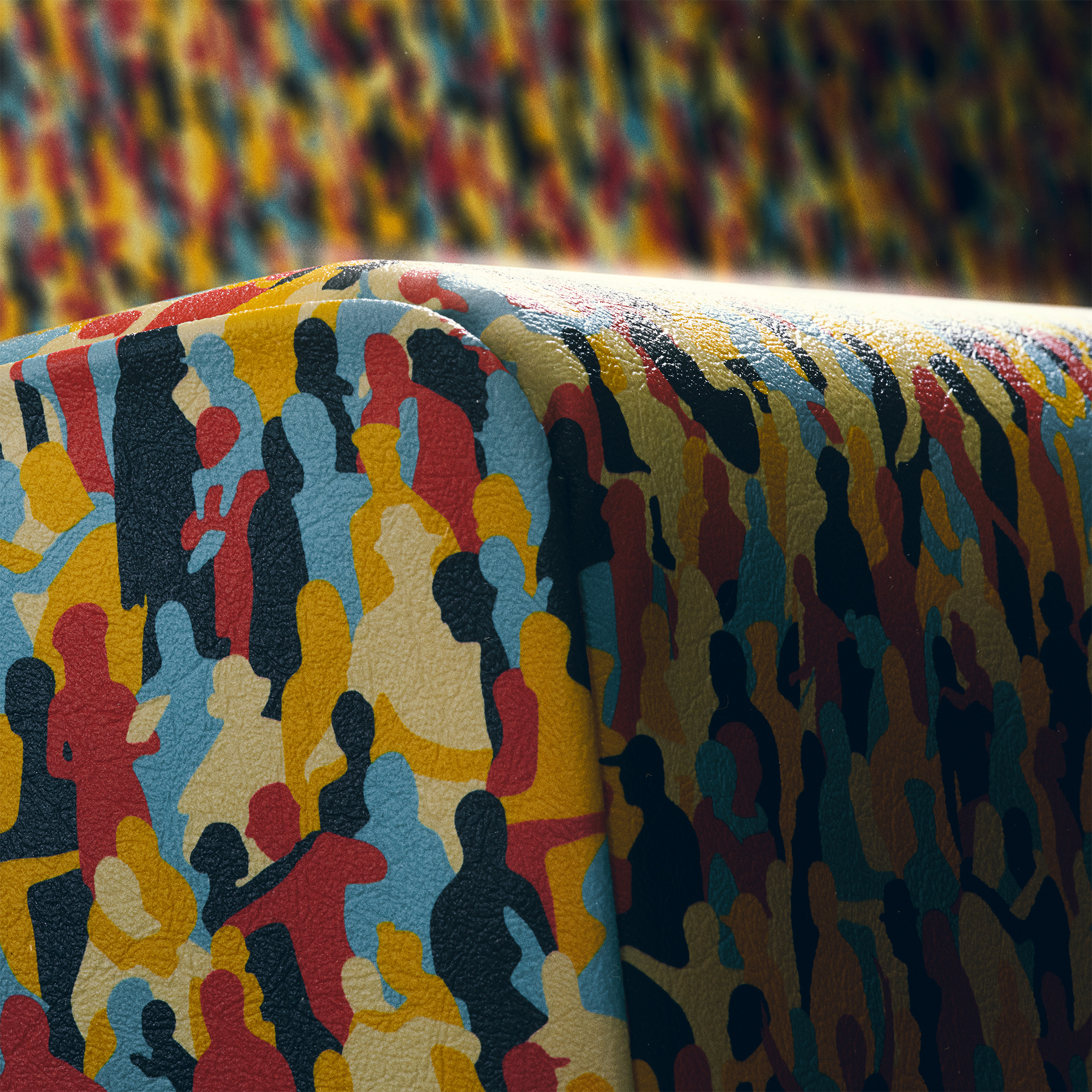 A close-up of a subway seat. the shiny material is made of the colorful silhouettes - The so-called Pattern of Tolerance, part of Jung von Matt’s Campaign for BVG, Berlin’s public transport company.