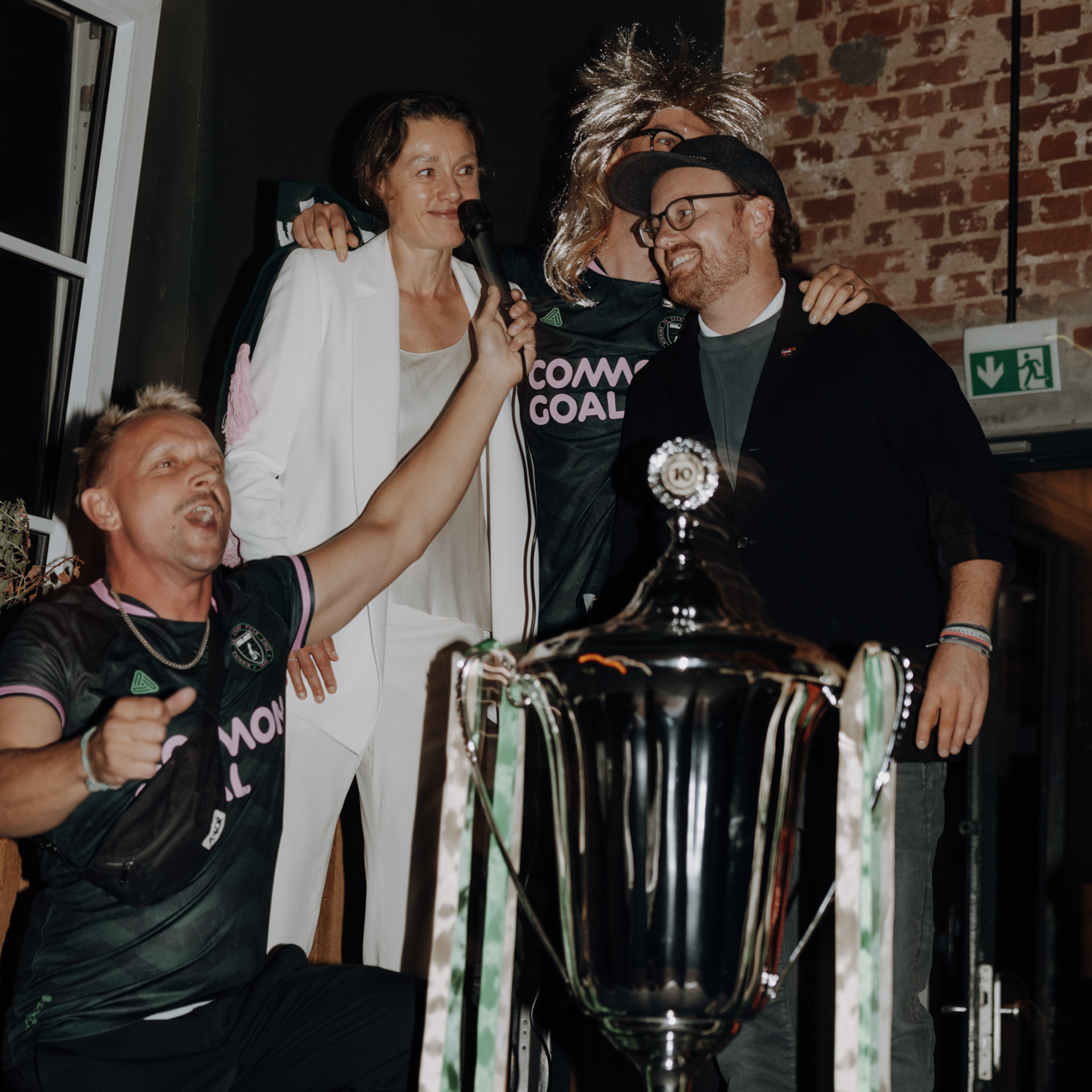 A group of people proudly posing with a trophy, celebrating their achievement and success.