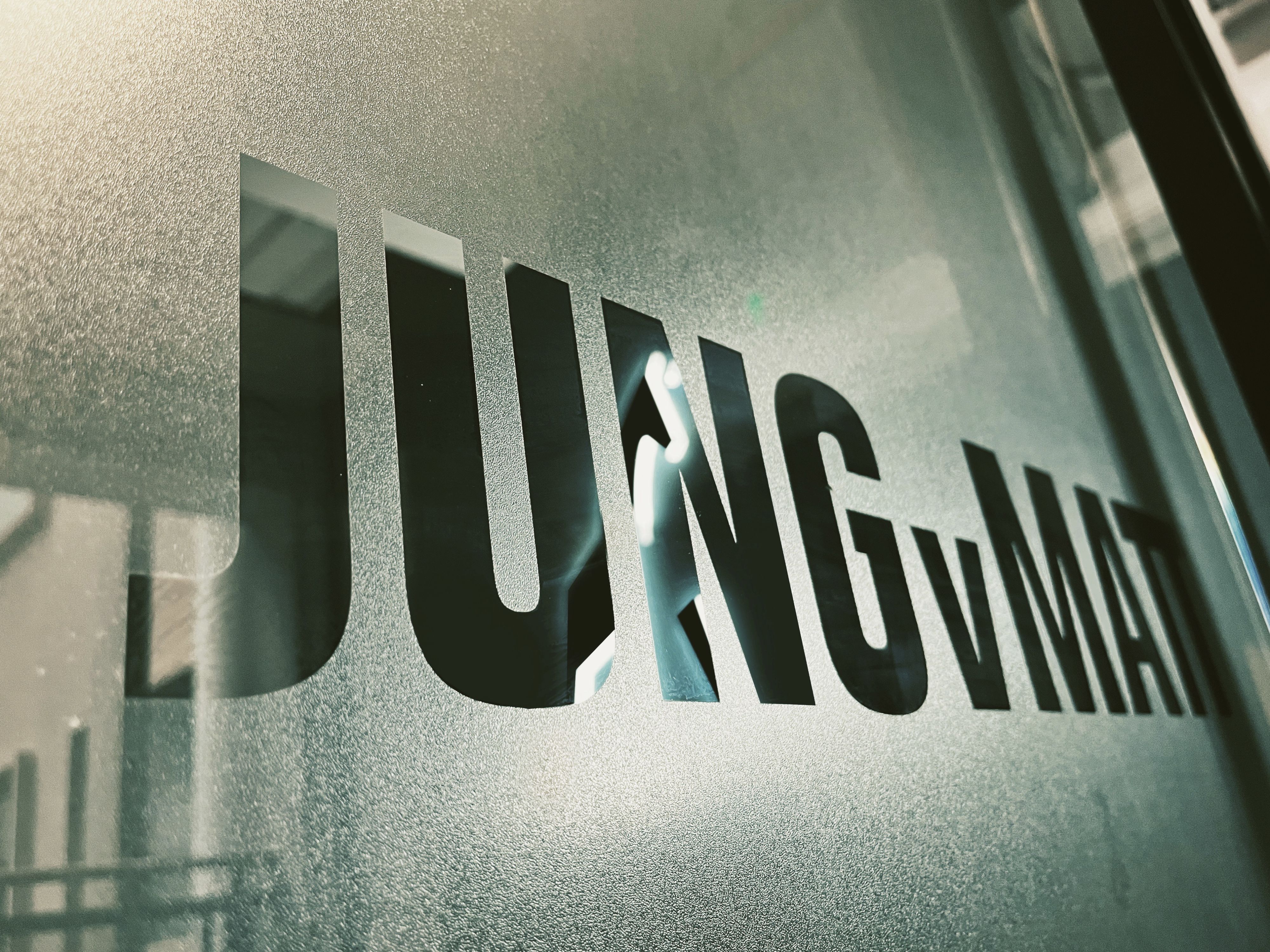 Image of a window in the office of Jung von Matt Shanghai. Pasted on it the slogan "JUNGVMATT".