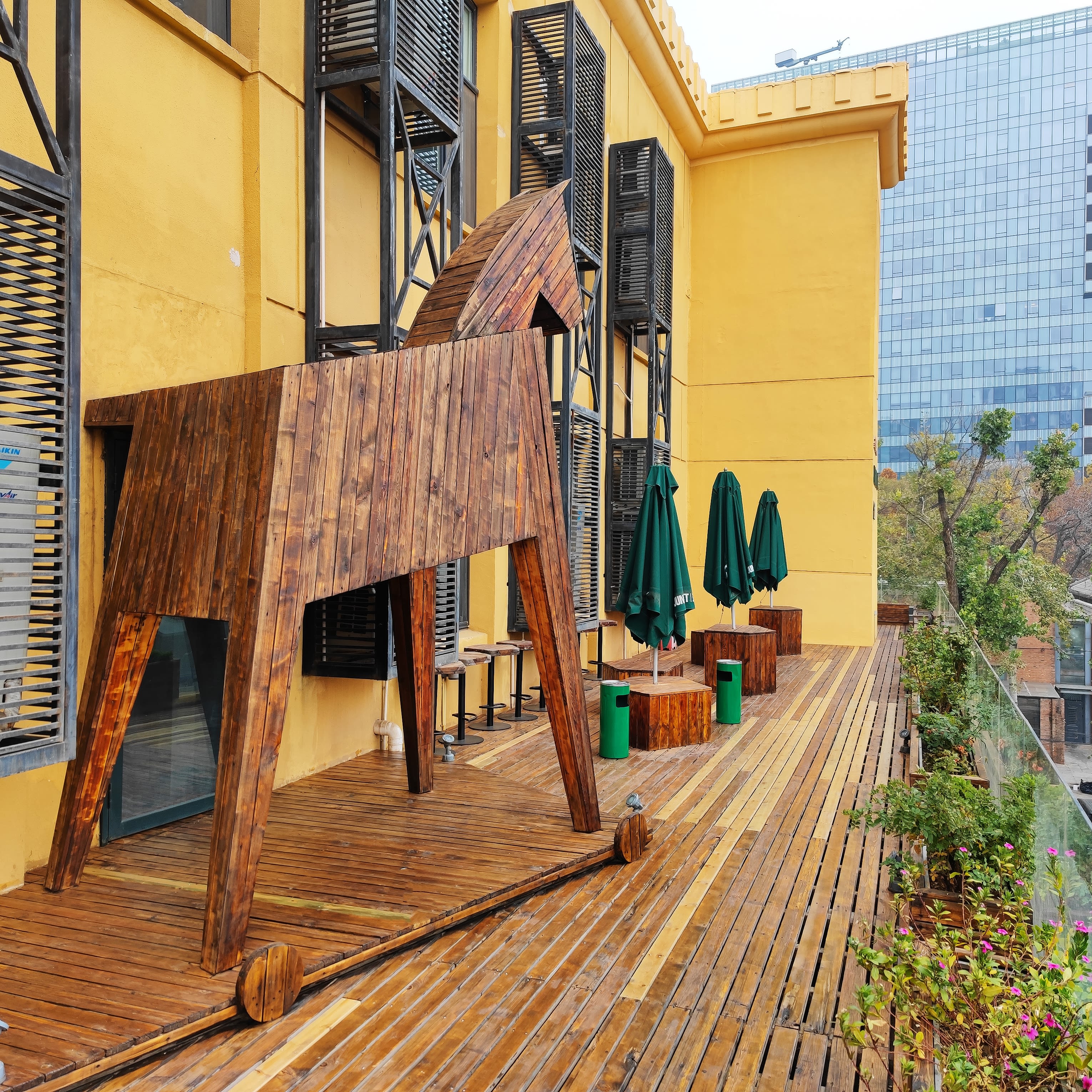 Picture of the wooden horse, the brand logo of Jung von Matt, standing on the terrace on the third floor of JvM's office building in Beijing.