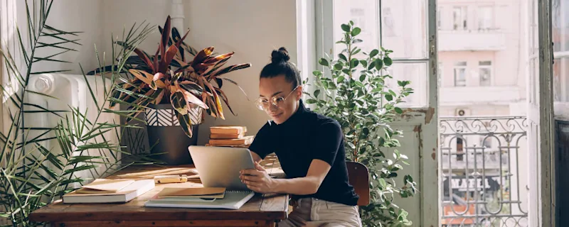 A women sitting at her desk in the sun while viewing self storage options from STOREX