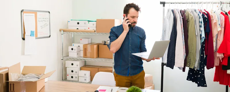 A businessman on the phone discussing self storage with a STOREX staff member.