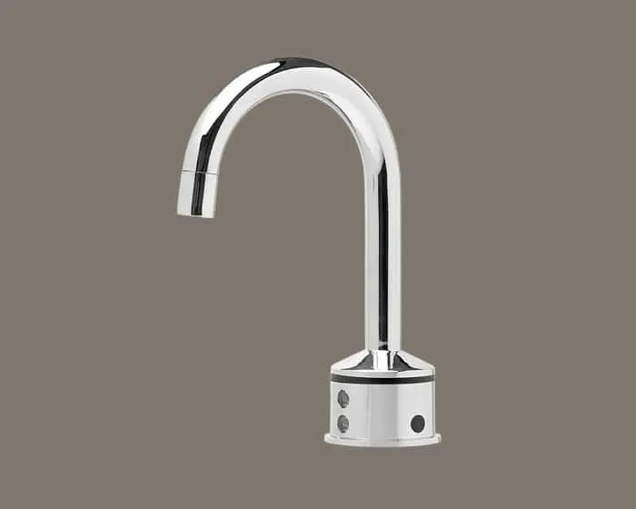 Chrome faucet with curved spout and cylindrical base with control buttons on gray background