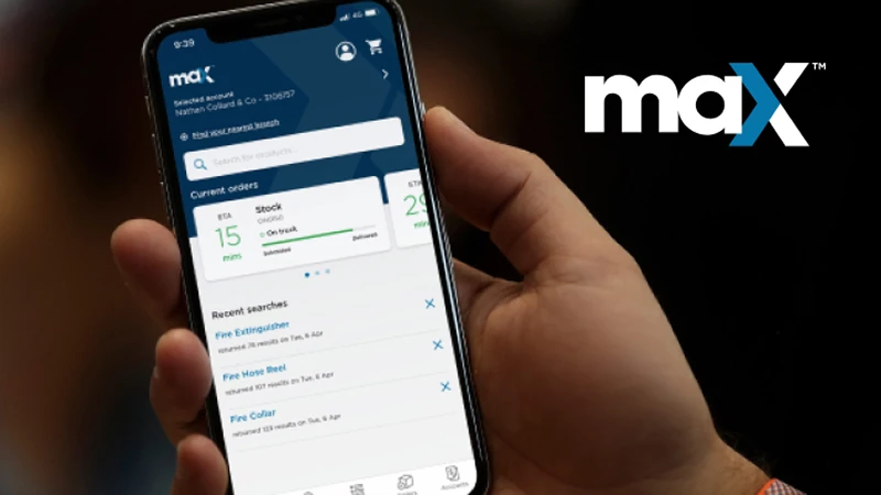 Hand holding smartphone displaying maX app interface with order tracking and recent searches visible
