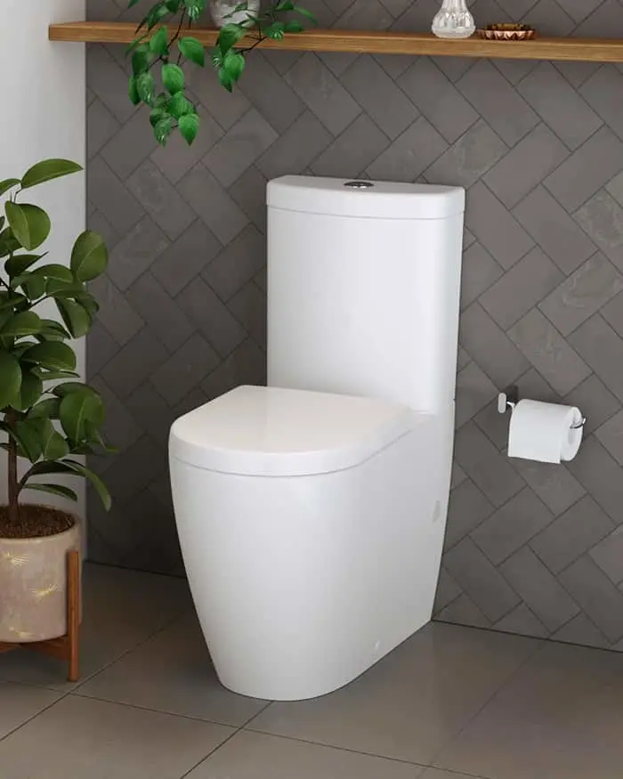 White modern toilet against gray herringbone tile wall with green plants and wooden shelf above