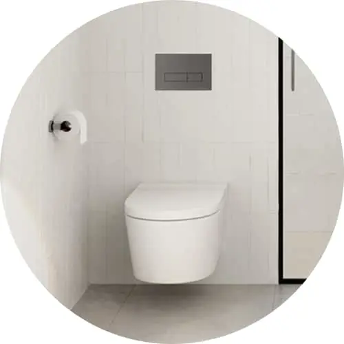 White wall-mounted toilet with gray flush plate in minimalist bathroom with white tile walls and glass shower panel
