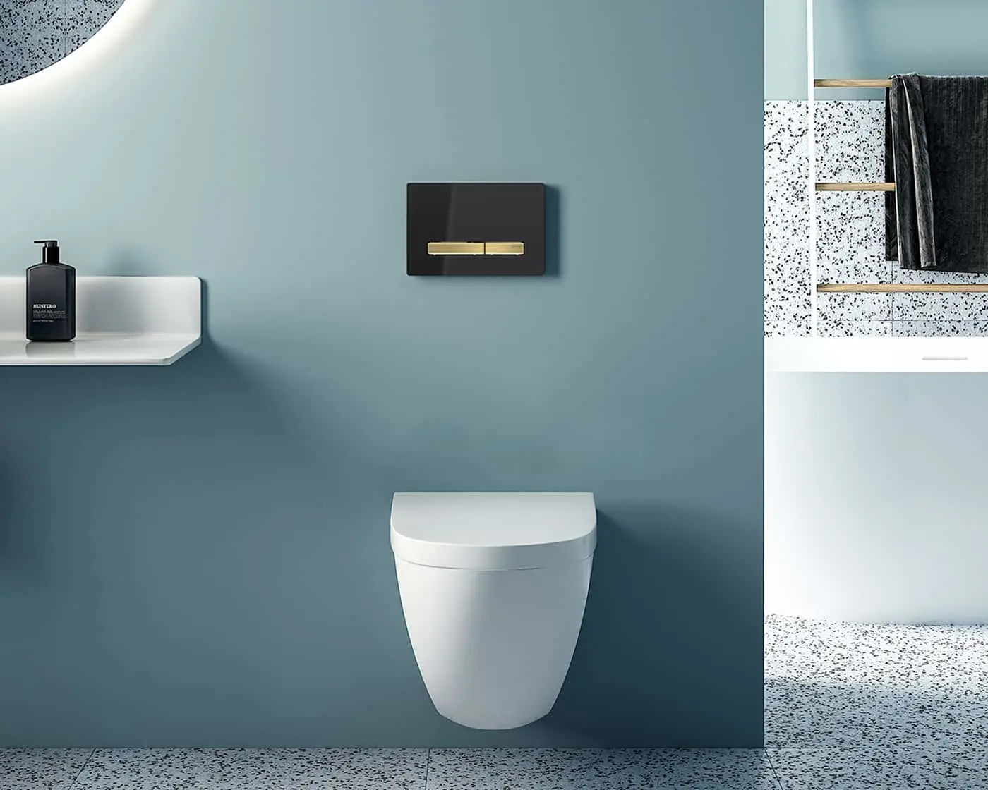 Modern bathroom with white wall-mounted toilet, dark flush plate with gold button, and terrazzo flooring.