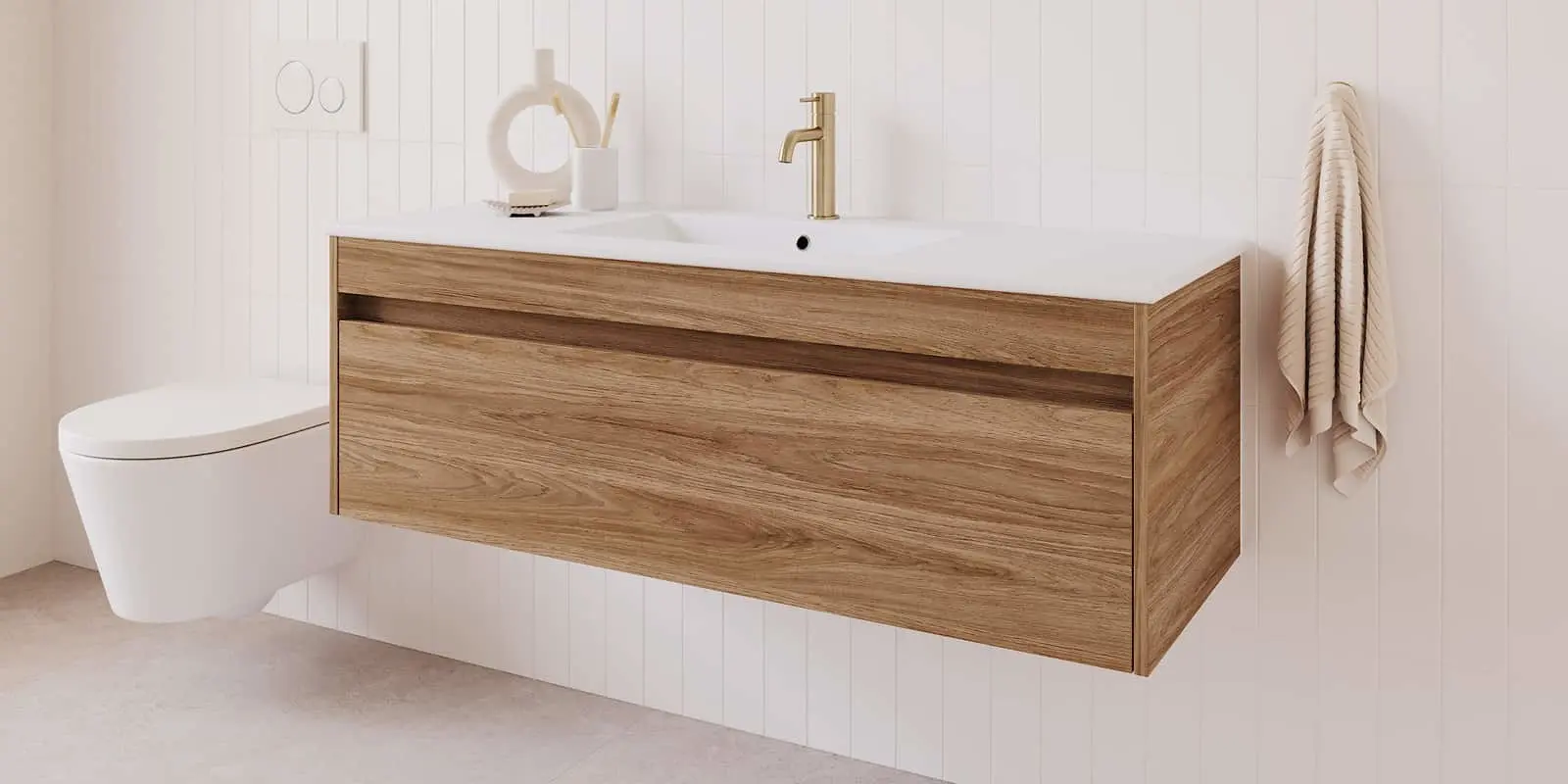 Wall-mounted wood vanity with white countertop and gold faucet next to a white toilet in a modern bathroom.