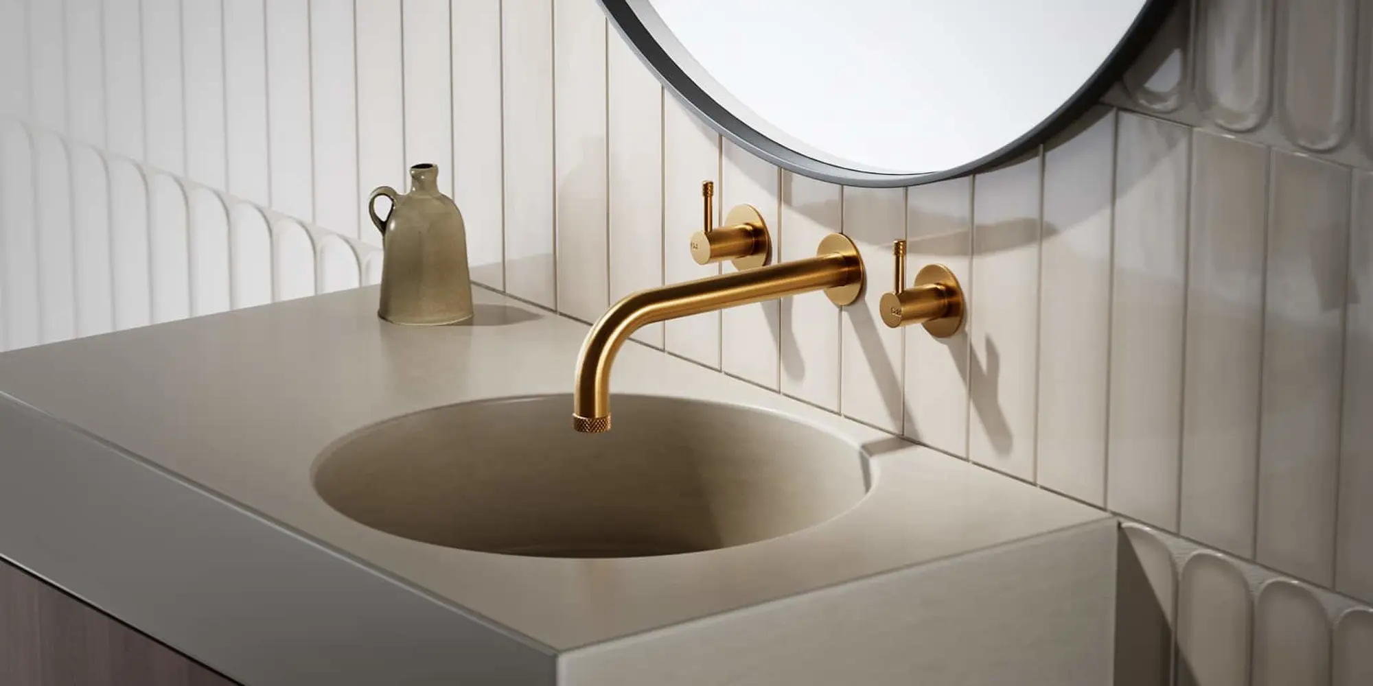 Bathroom sink with beige countertop, brass wall-mounted faucet, white tile backsplash, and round mirror above.