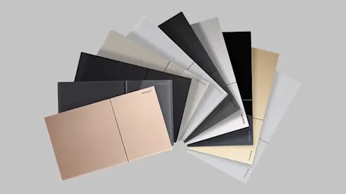 Fan of material samples in neutral colors including black, white, gray, and beige arranged on a light gray surface.