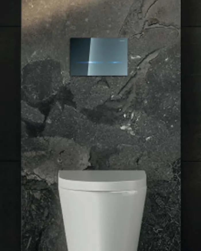 White modern toilet against dark gray textured stone wall with blue flush plate mounted above