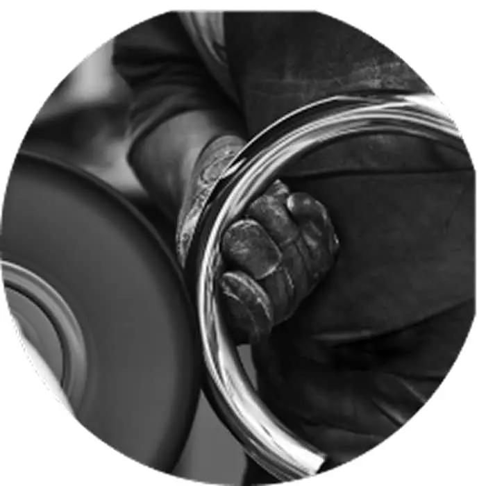Close-up black and white image of a hand holding a curved metal pipe.