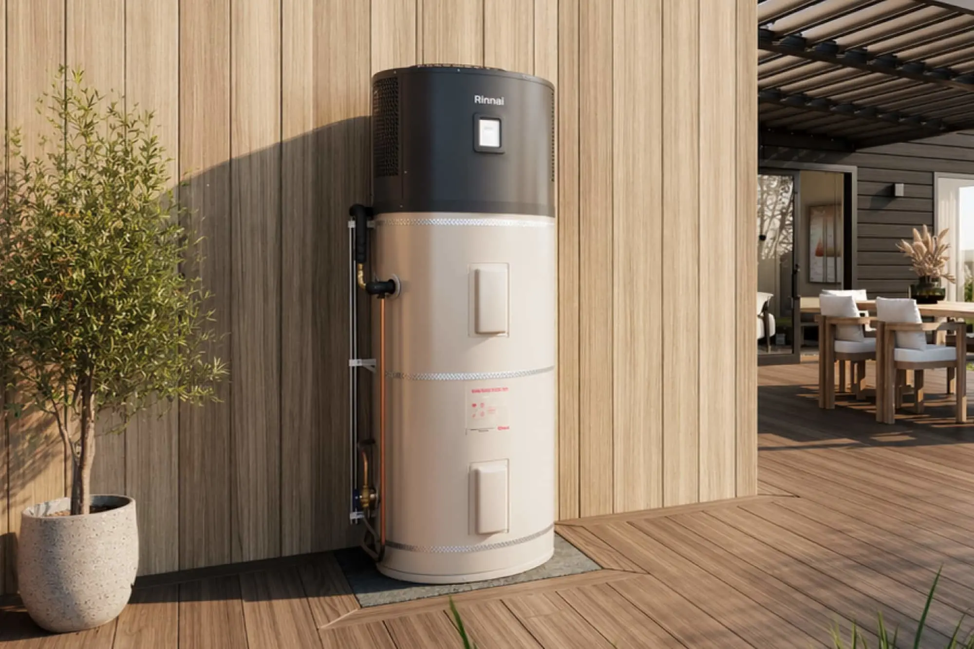 Rinnai hot water heater with black top and beige tank installed on outdoor wooden deck next to potted plant.