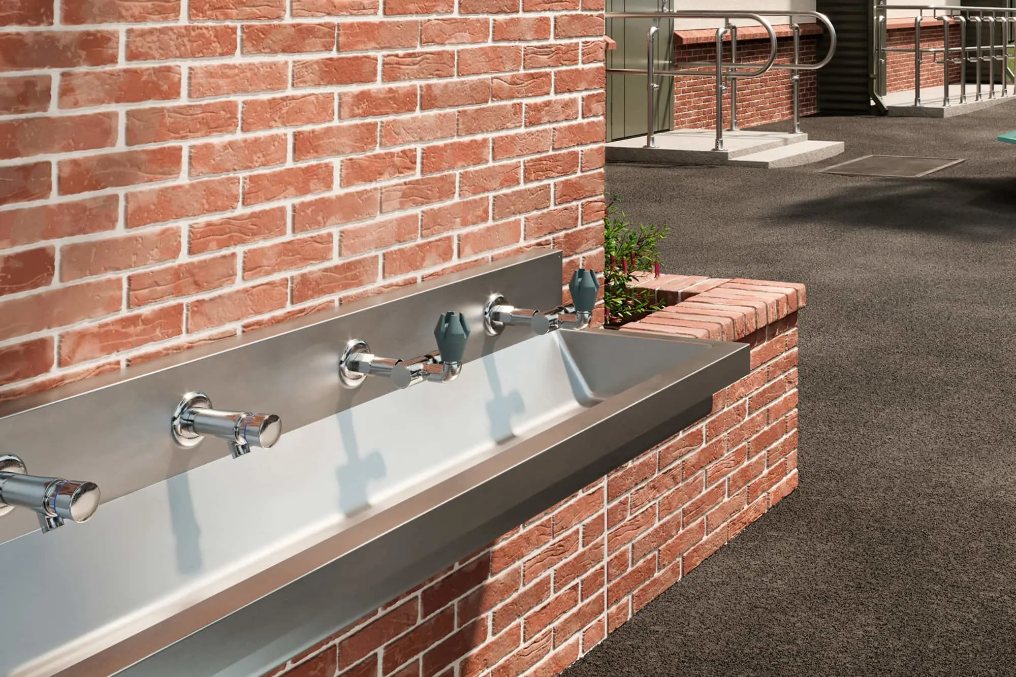 Outdoor stainless steel drinking fountain with chrome faucets built into red brick wall near building entrance.