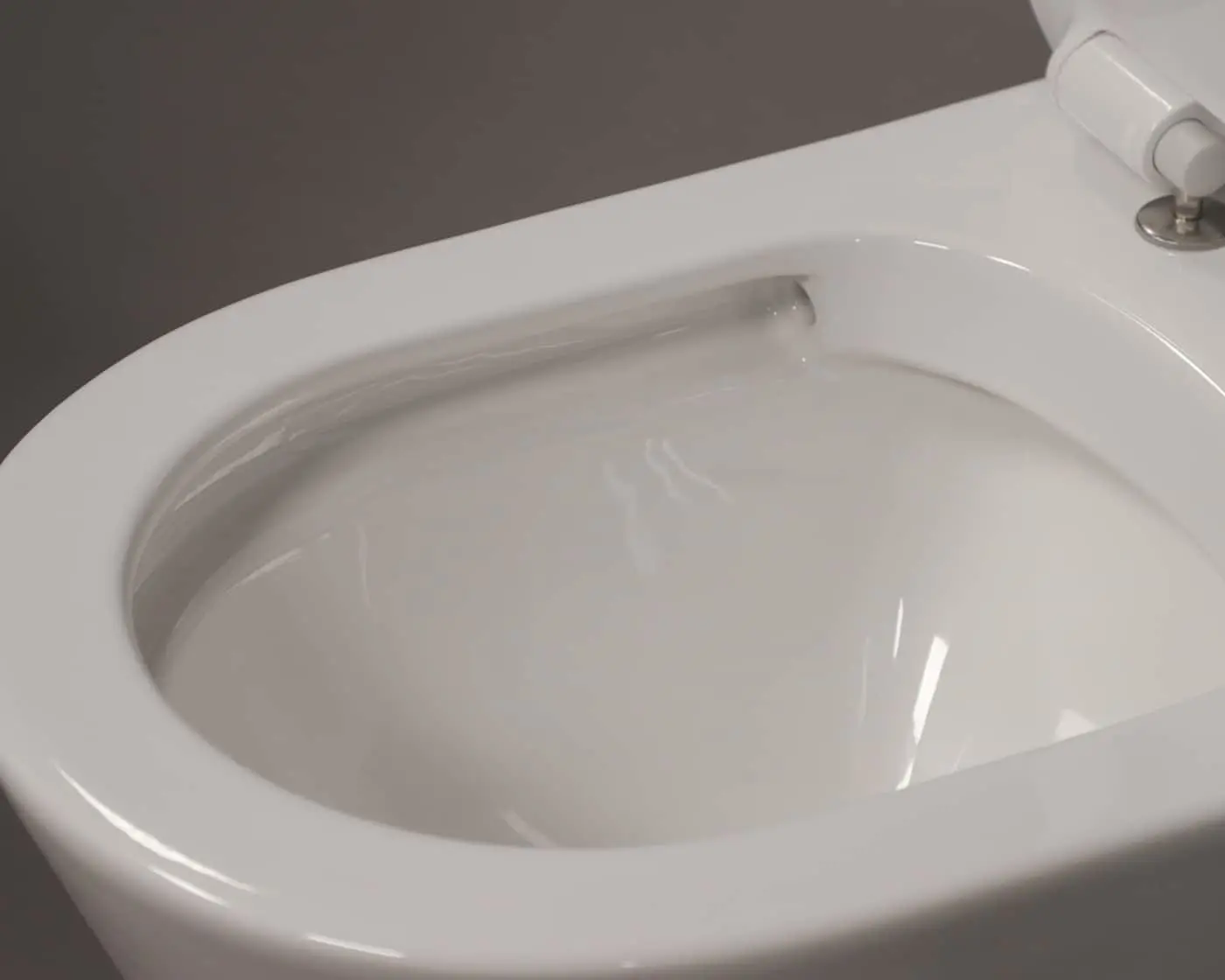 White toilet bowl with water swirling during flush against gray wall