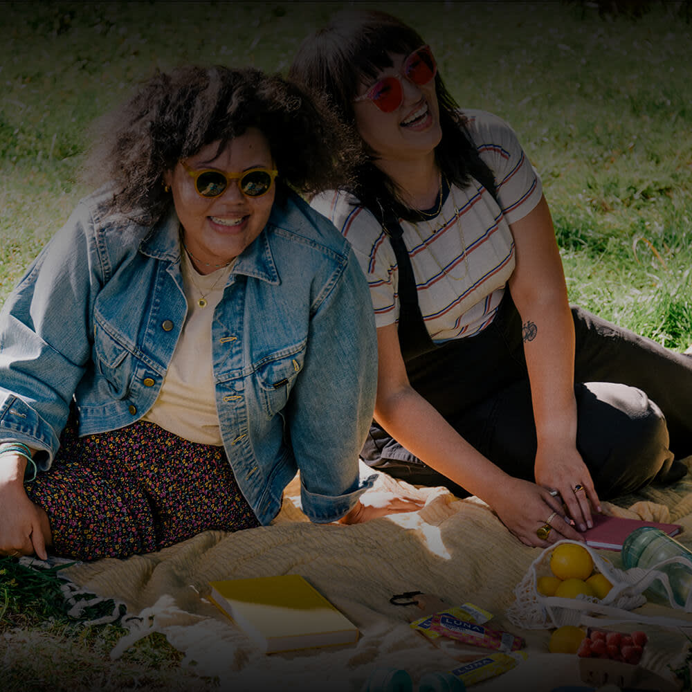 Two girls on blanket in grass