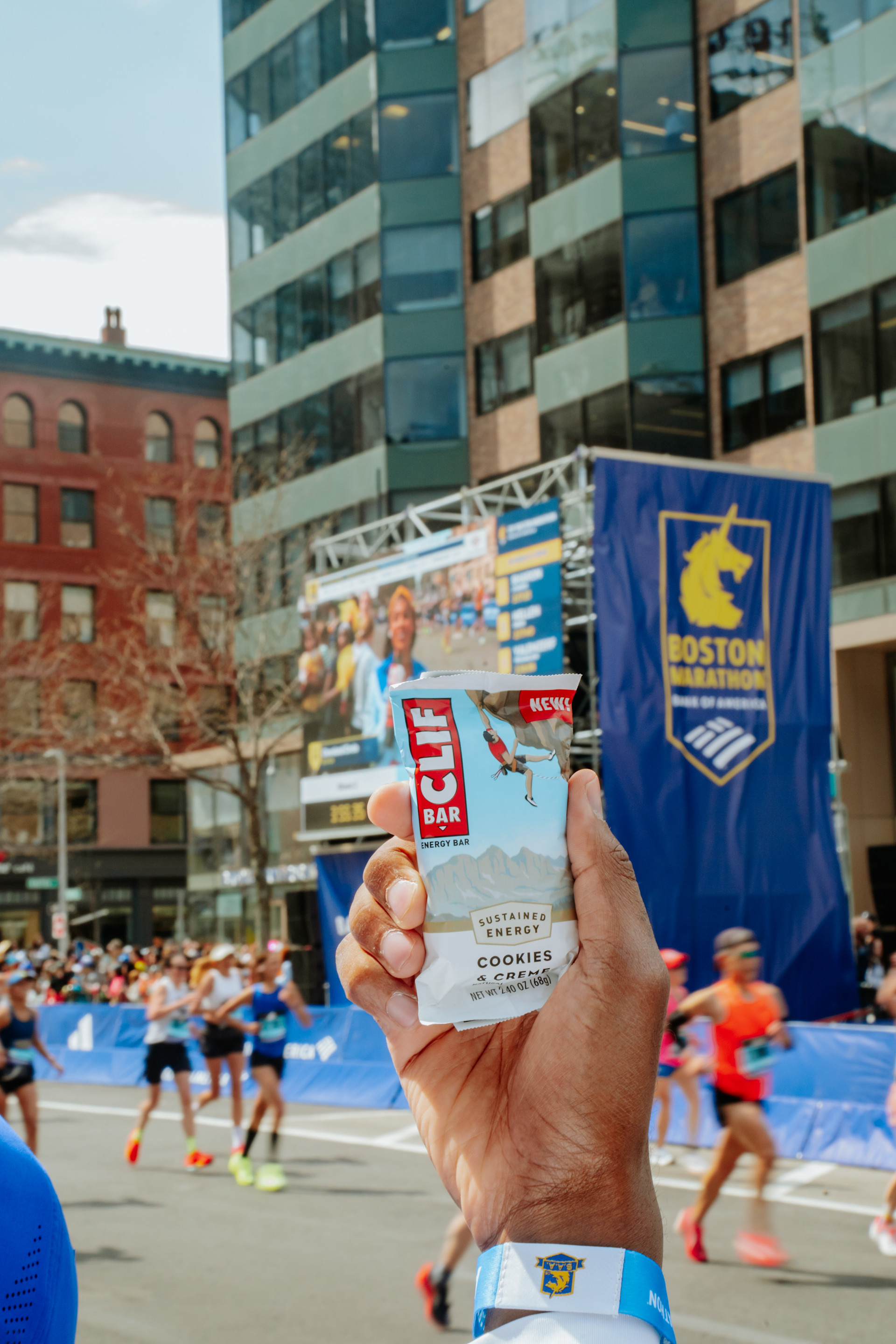 Hand Holding Up a CLIF Bar at the Boston Marathon